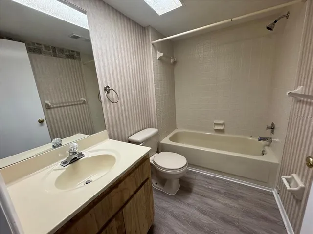 a bathroom with a sink toilet a mirror and shower
