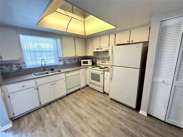 a kitchen with white cabinets and white appliances