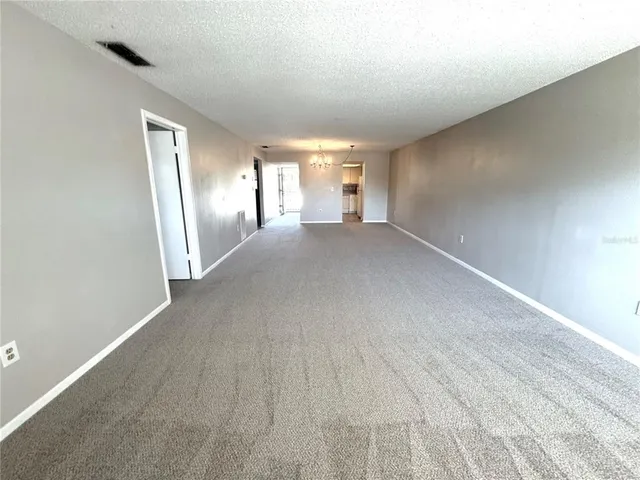 a view of a big room with windows and chandelier fan