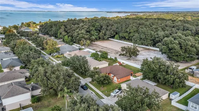 an aerial view of a city with lots of residential buildings ocean and mountain view in back