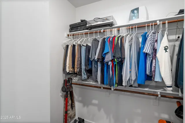 a view of walk in closet with clothes