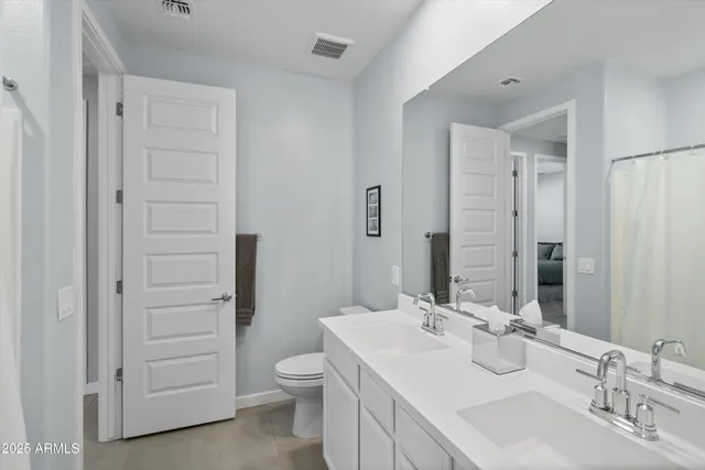 a bathroom with a toilet a sink a mirror and a shower