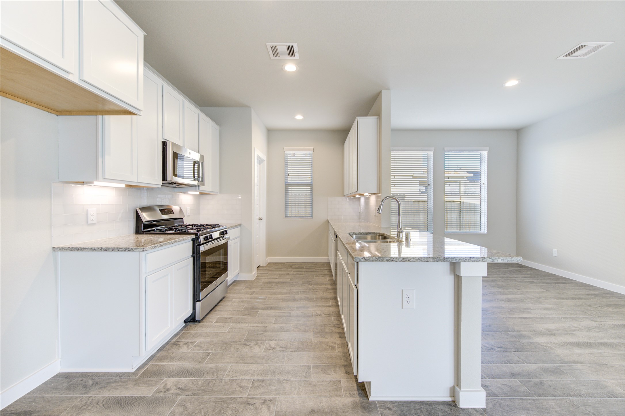 2623 Finley Lane Rosenberg, TX 77471 - Photo 16 of 49 a kitchen with stainless steel appliances granite countertop a stove top oven a sink a refrigerator and white cabinets with wooden floor