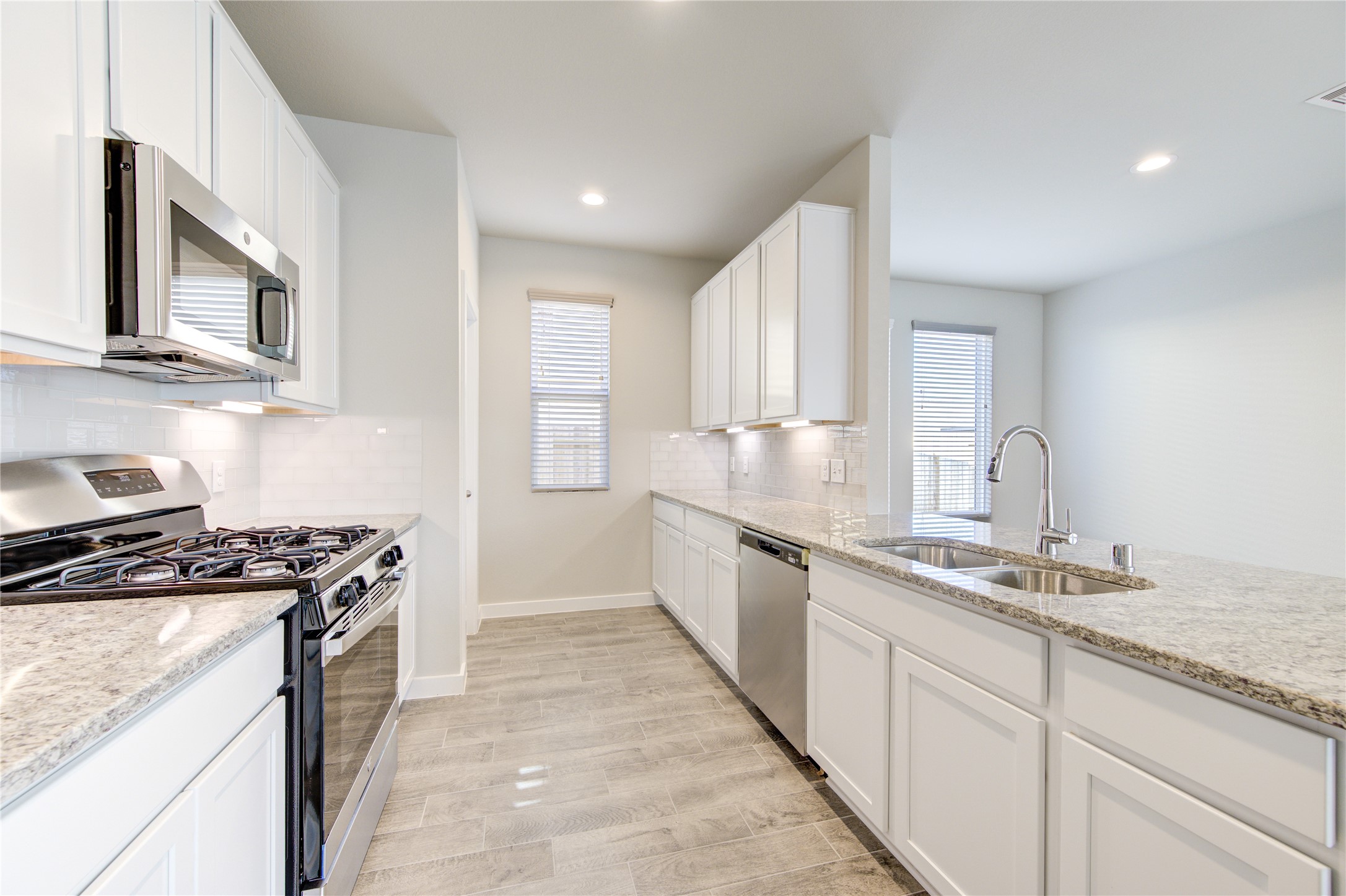 2623 Finley Lane Rosenberg, TX 77471 - Photo 18 of 49 a kitchen with stainless steel appliances granite countertop a stove a sink and a microwave