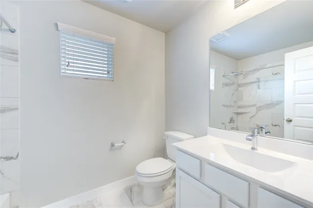 a bathroom with a sink toilet and a mirror