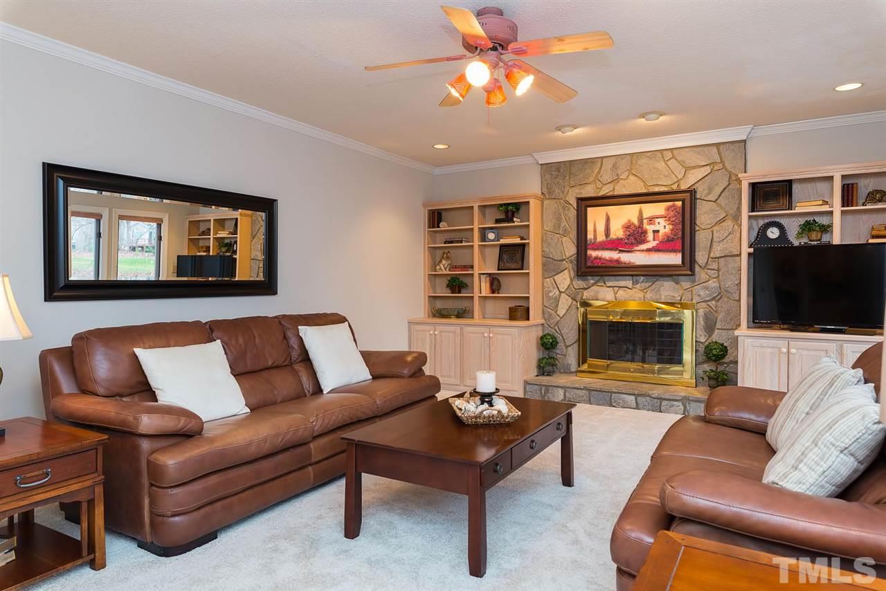8816 Ross Court Raleigh, NC 27613 - Photo 3 of 25 a living room with furniture a flat screen tv and a fireplace