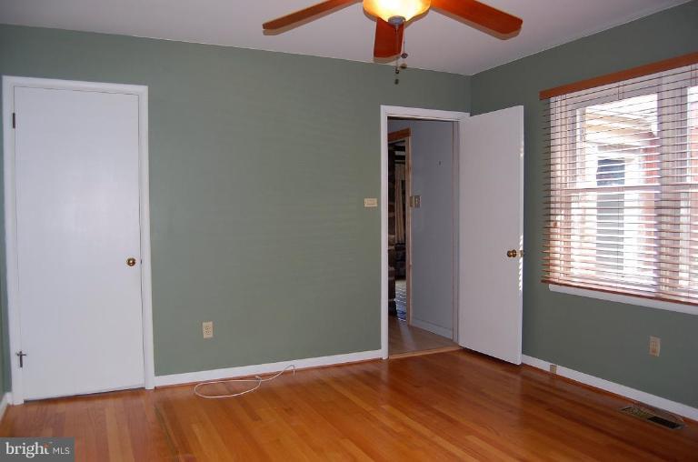 1207 Culvert Road Towson, MD 21286 - Photo 21 of 29 an empty room with wooden floor and windows