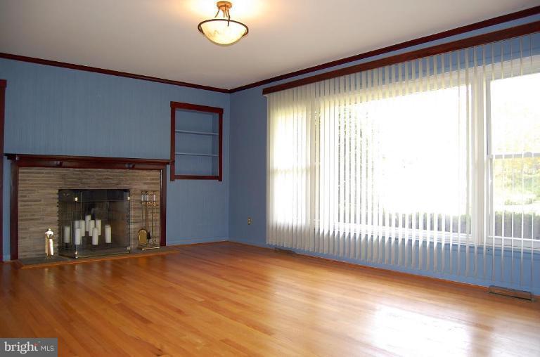 1207 Culvert Road Towson, MD 21286 - Photo 7 of 29 an empty room with fireplace and windows