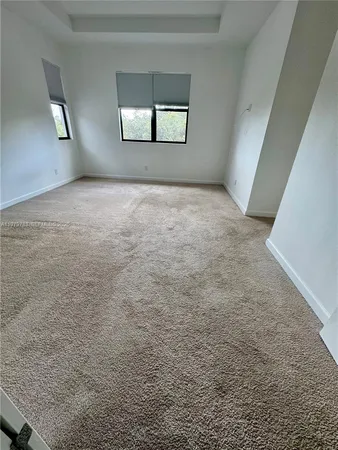 an empty room with windows and mirror