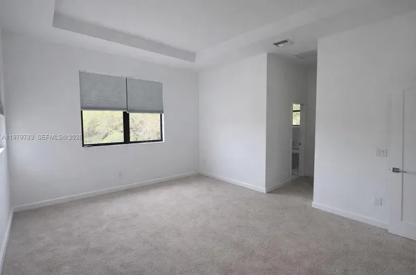an empty room with a window and a bathroom