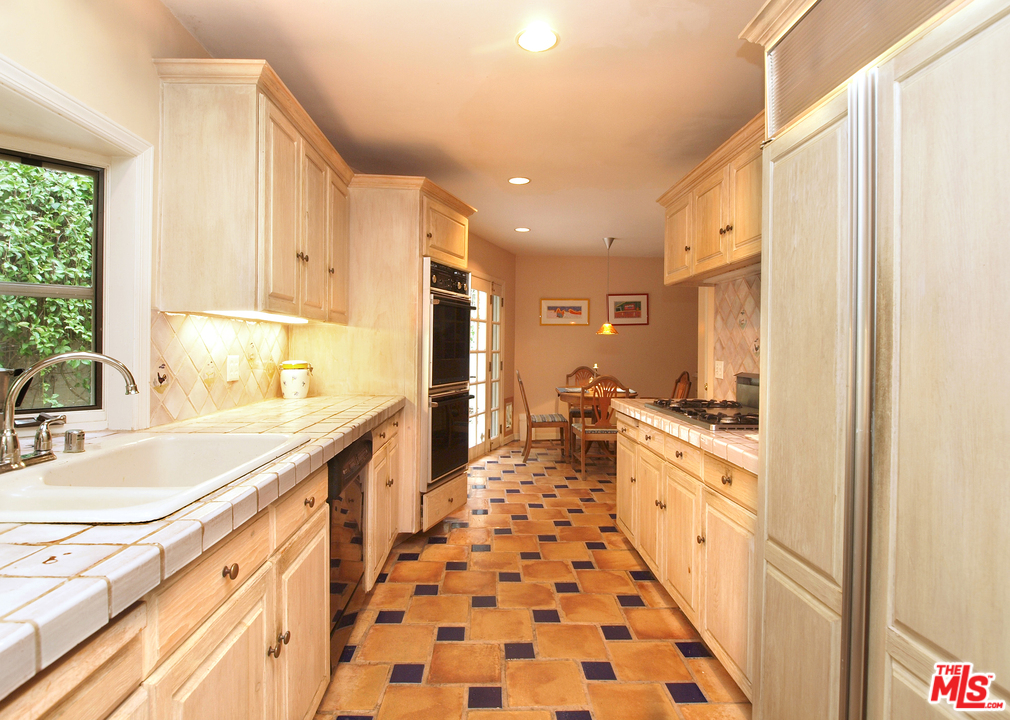 507 West Rustic Road Santa Monica, CA 90402 - Photo 5 of 32 a large kitchen with granite countertop a sink and a refrigerator