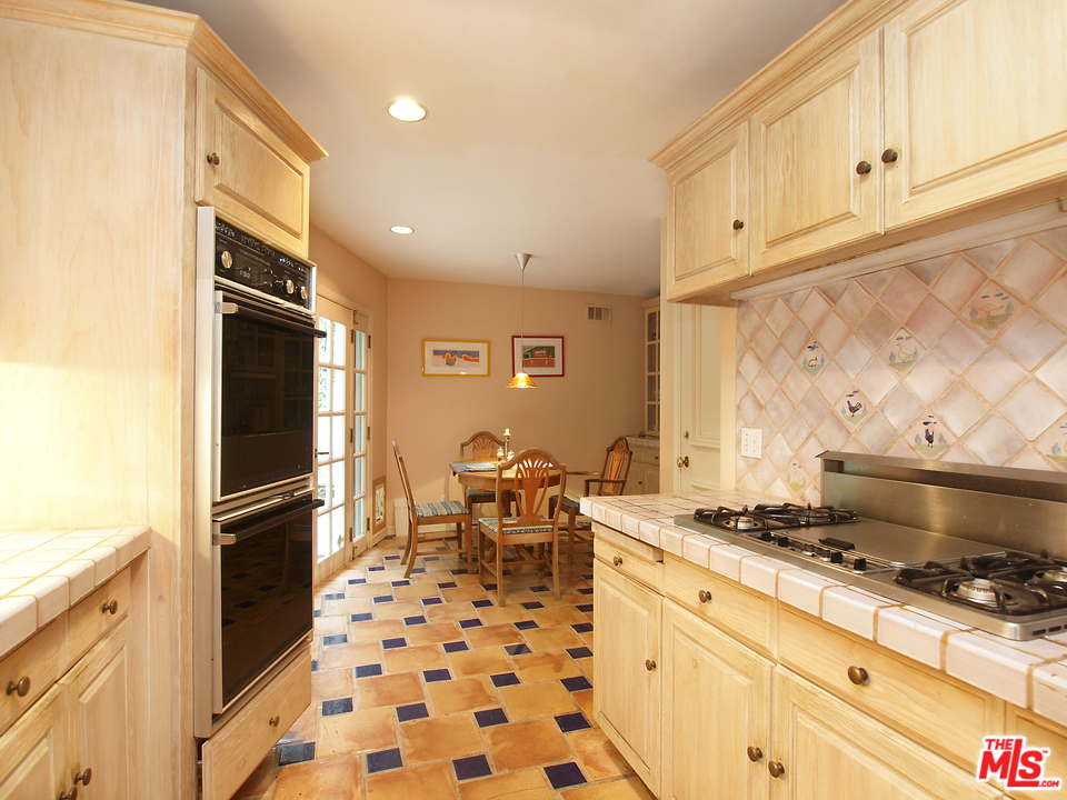 507 West Rustic Road Santa Monica, CA 90402 - Photo 6 of 32 a kitchen with granite countertop a stove and a refrigerator