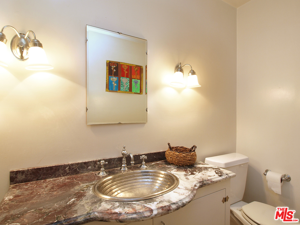 507 West Rustic Road Santa Monica, CA 90402 - Photo 8 of 32 a bathroom with a granite countertop sink and a mirror