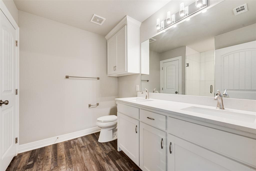 625 Copenhavr Street Pilot Point, TX 76258 - Photo 14 of 20 Full bath featuring double vanity, dark wood-type flooring, and a shower stall