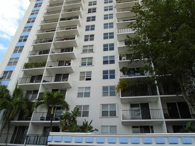 a front view of a multi story building with a yard