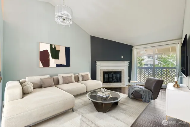 a living room with furniture a fireplace and a large window