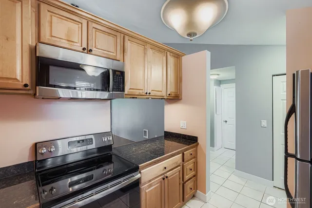 a kitchen with stainless steel appliances granite countertop a refrigerator and a stove top oven