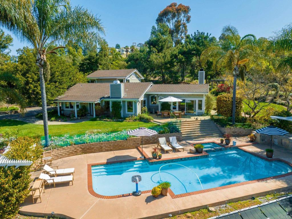 an aerial view of a house with swimming pool patio and outdoor seating