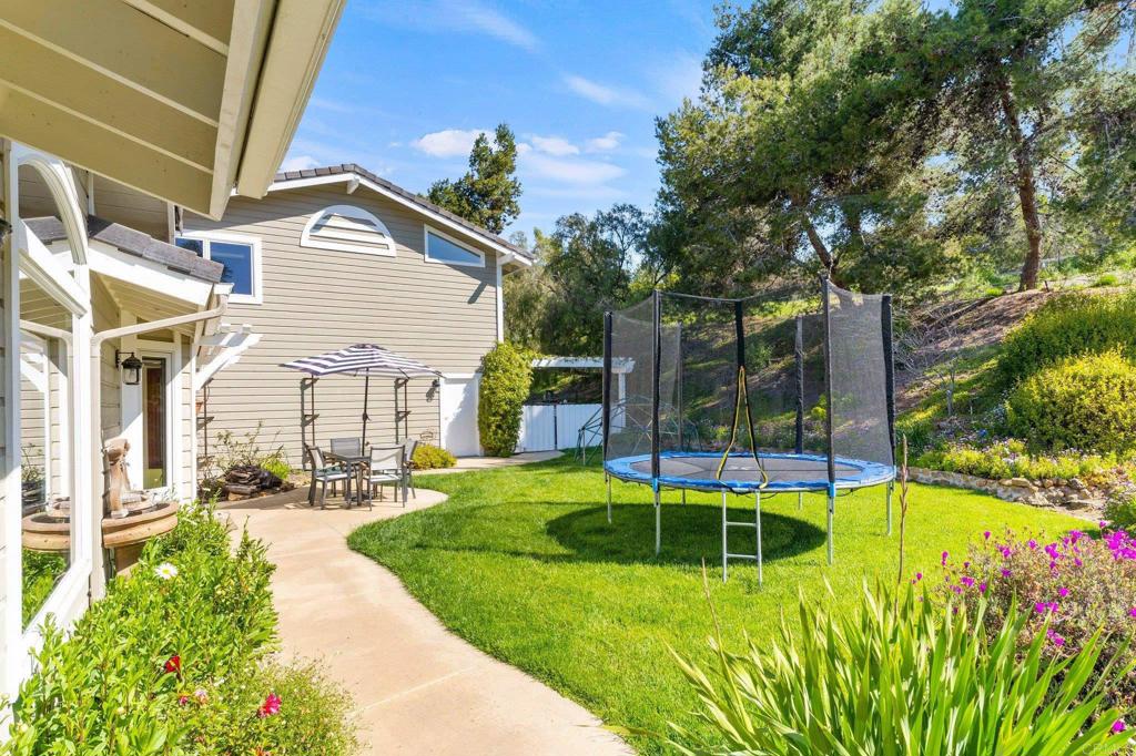 3355 Lone Jack Road Encinitas, CA 92024 - Photo 14 of 54 a view of a backyard with table and chairs and potted plants