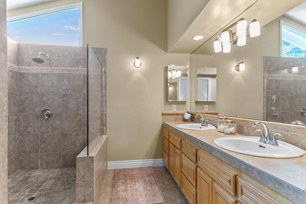 3355 Lone Jack Road Encinitas, CA 92024 - Photo 34 of 54 a bathroom with a double vanity sink mirror and shower