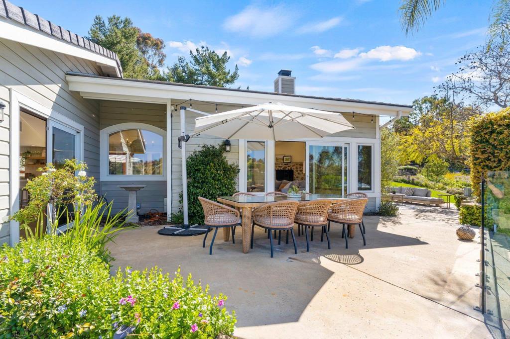 3355 Lone Jack Road Encinitas, CA 92024 - Photo 10 of 54 a view of a patio with table and chairs potted plants and floor to ceiling window