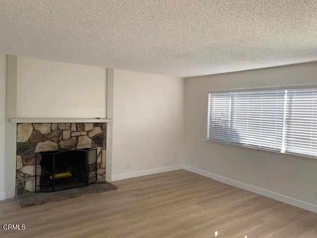 a view of an empty room with a fireplace and a window
