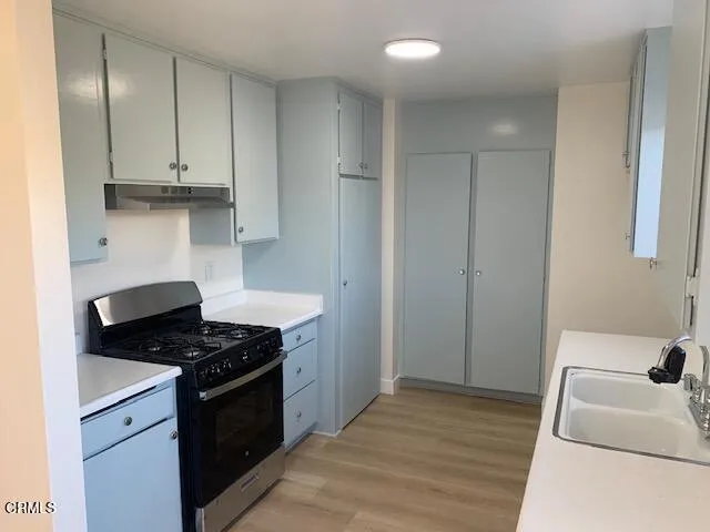 a kitchen with granite countertop a sink stove and refrigerator
