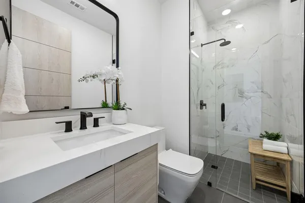 a bathroom with a sink a toilet and shower