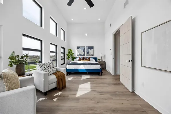 a bedroom with furniture and a large window