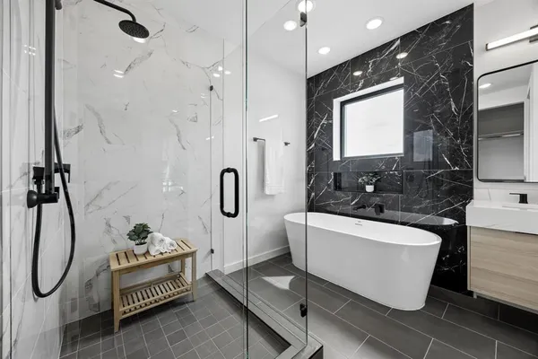 a bathroom with a tub sink and mirror