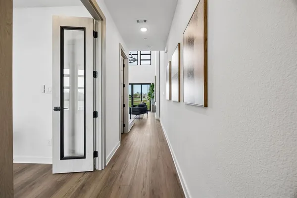 a view of a hallway with wooden floor