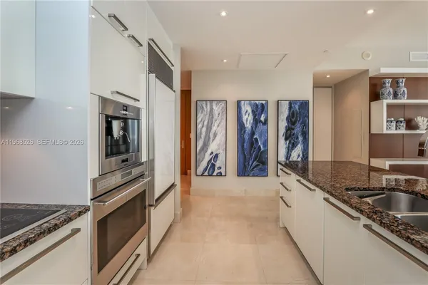 a kitchen with stainless steel appliances granite countertop a sink refrigerator and microwave