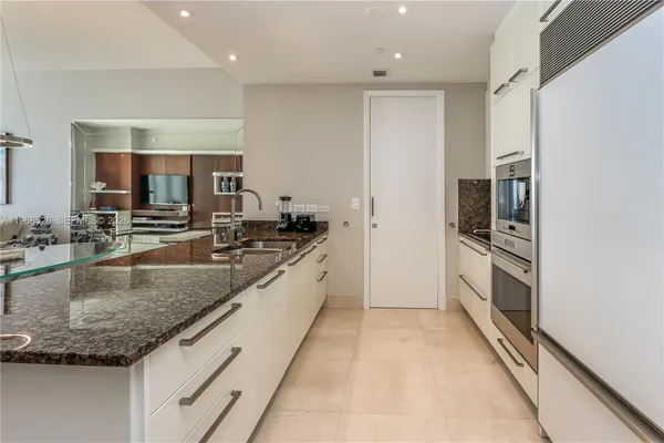 a kitchen with granite countertop a sink and stainless steel appliances