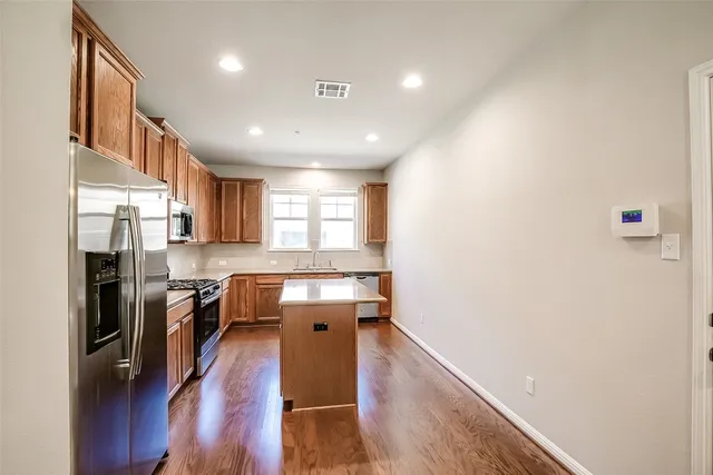 a kitchen with stainless steel appliances granite countertop a sink a microwave a stove and white cabinets
