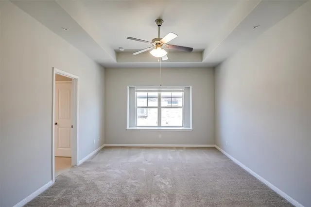 an empty room with a window and a fan
