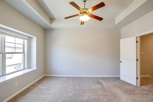 an empty room with fan and windows