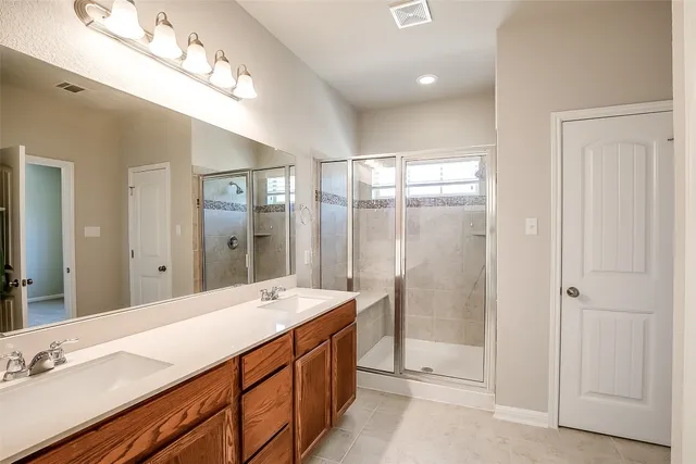 a bathroom with a mirror a shower and a sink