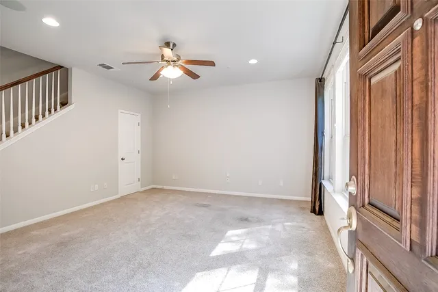 an empty room with windows and fan