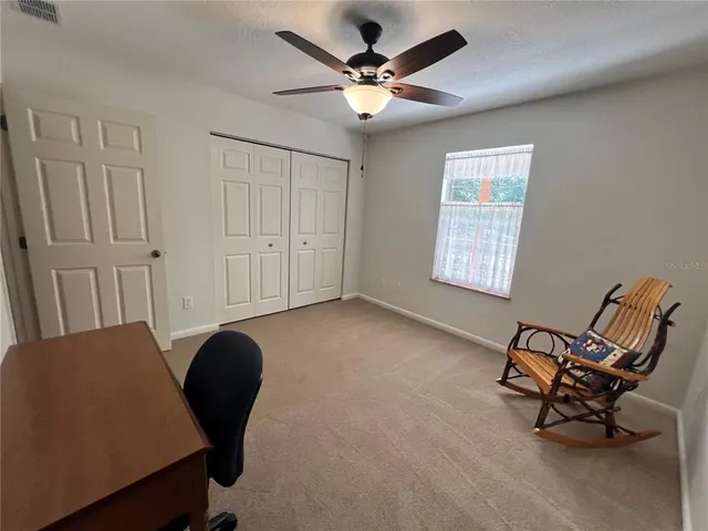 a view of a workspace with furniture and a window