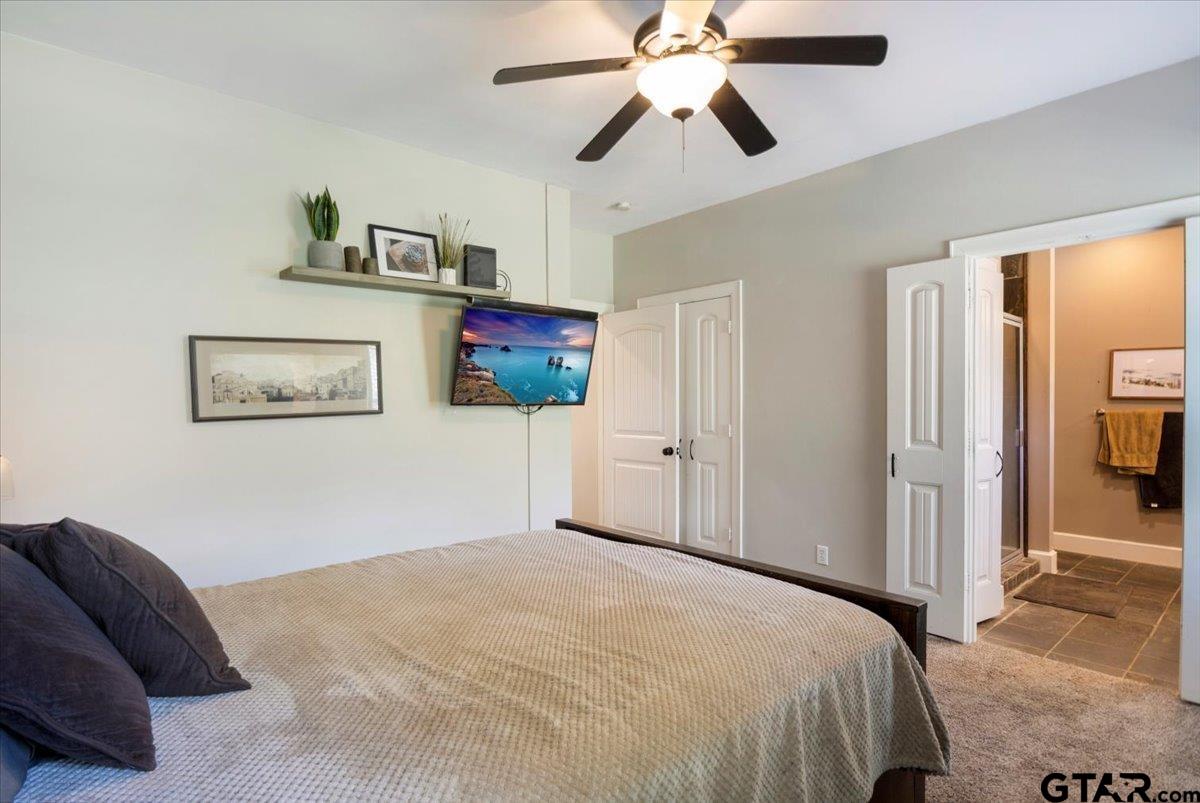 19577 Dove Ridge Lane Lindale, TX 75771 - Photo 16 of 42 a bedroom with a bed and a chandelier