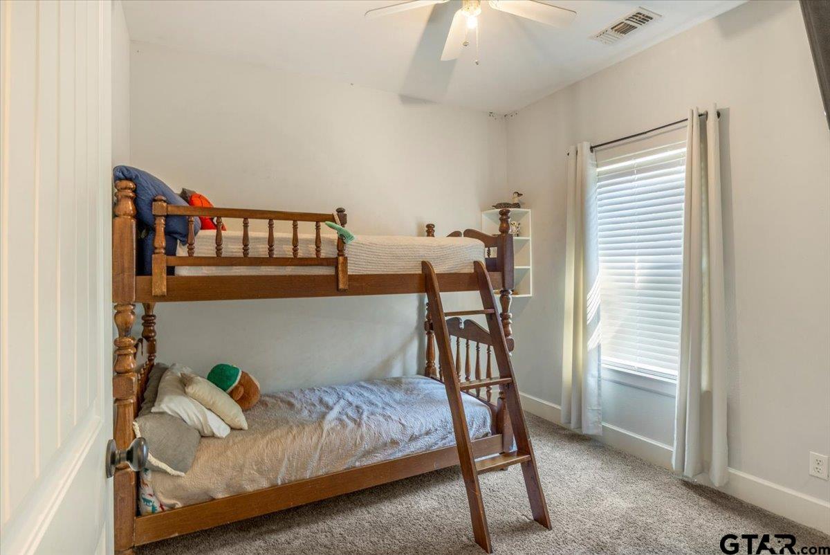 19577 Dove Ridge Lane Lindale, TX 75771 - Photo 22 of 42 a bedroom with a bed and a book shelf