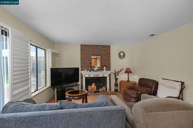 a living room with furniture a fireplace and a flat screen tv
