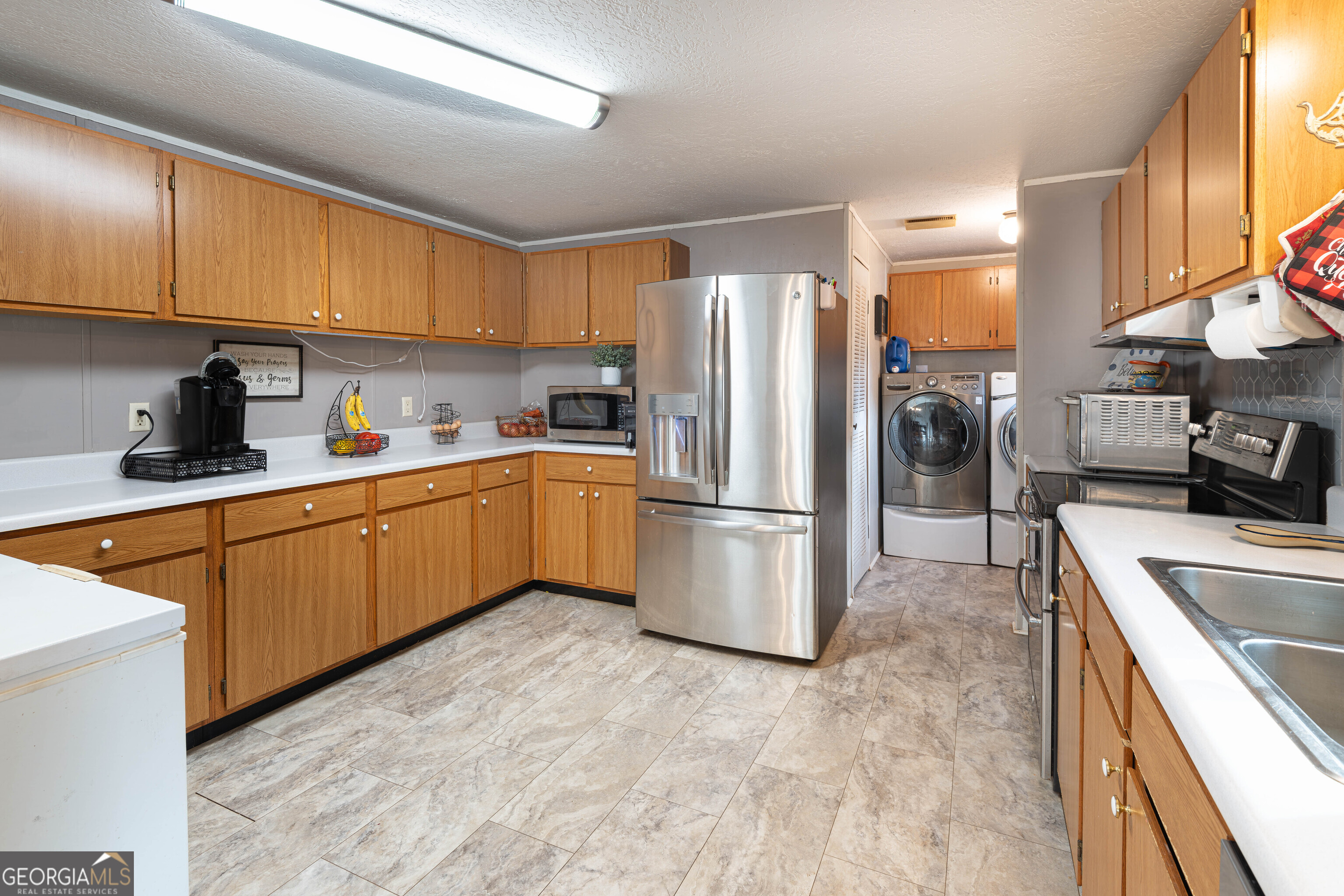 161 Cherokee Trail Forsyth, GA 31029 - Photo 28 of 39 a kitchen with a sink a refrigerator and cabinets