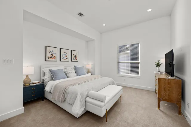 a spacious bedroom with a bed and a lamp