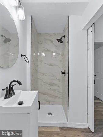 a bathroom with a sink mirror and shower