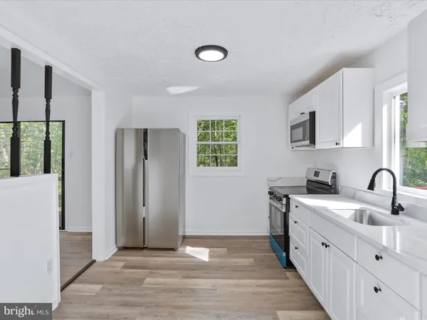 a kitchen with stainless steel appliances granite countertop a sink a stove and a refrigerator