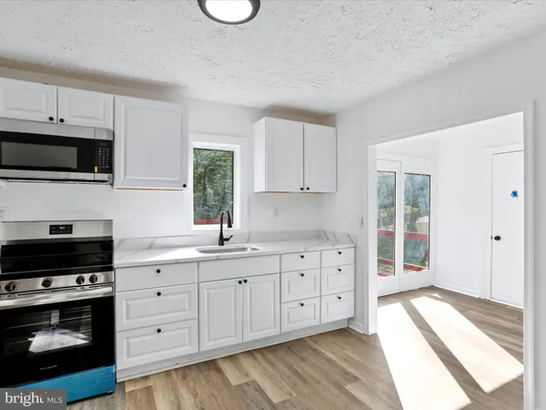 a kitchen with cabinets appliances and a window