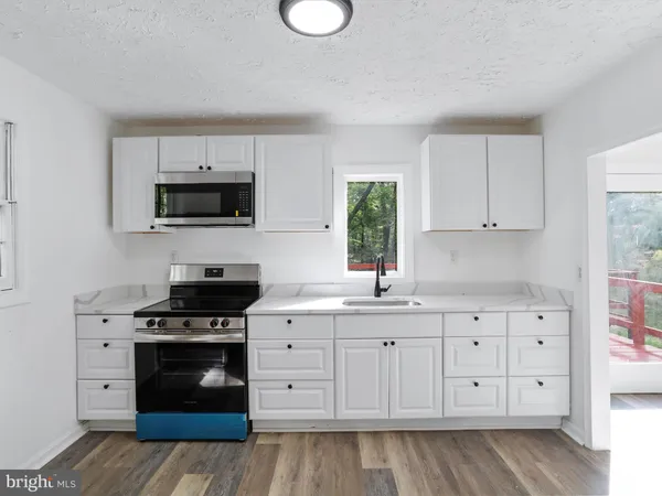 a kitchen with white cabinets and stainless steel appliances
