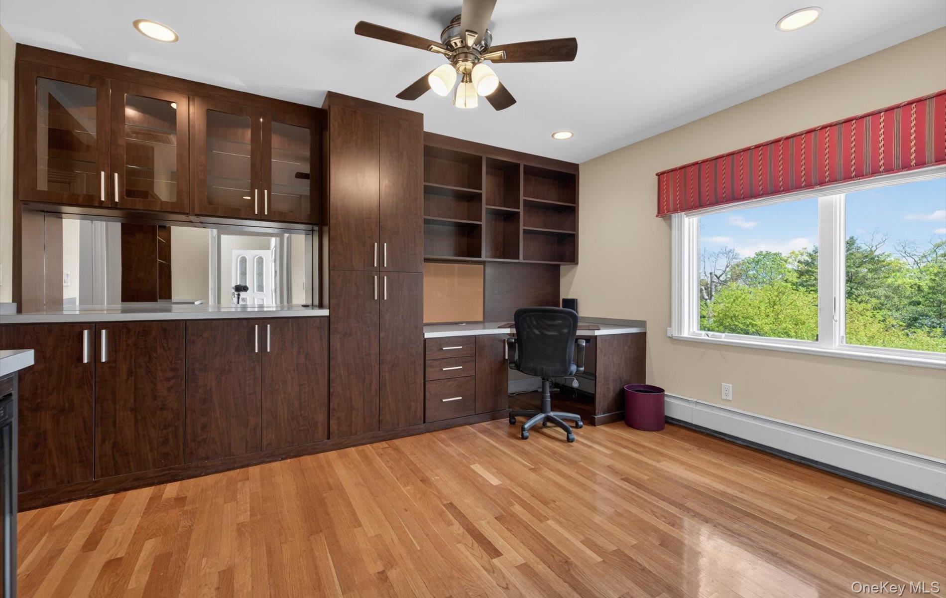 16 East Slope Road Bayville, NY 11709 - Photo 15 of 48 Custom built-in cabinetry with glass-front uppers, ample counter space, rich wood-finish flooring, recessed lighting, and a large window
