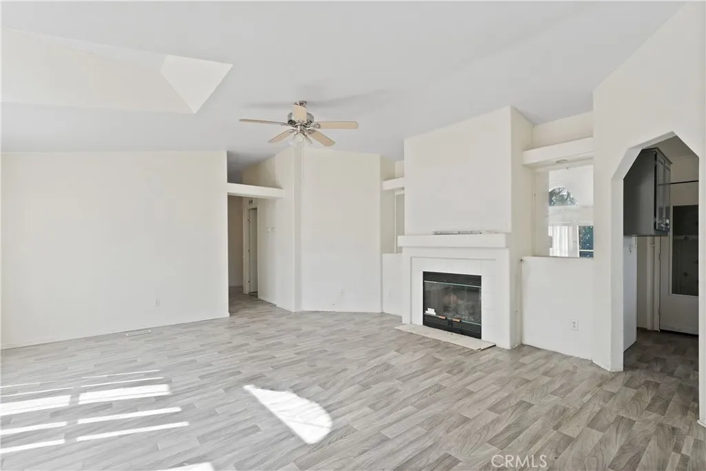 22540 Markham Street Perris, CA 92570 - Photo 14 of 20 a view of a livingroom with a fireplace a ceiling fan and wooden floor